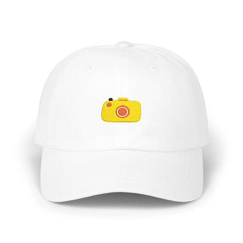 White capture baseball cap, front view with yellow camera embroidery and orange lens
